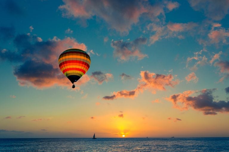 Air balloon over sea at sunset