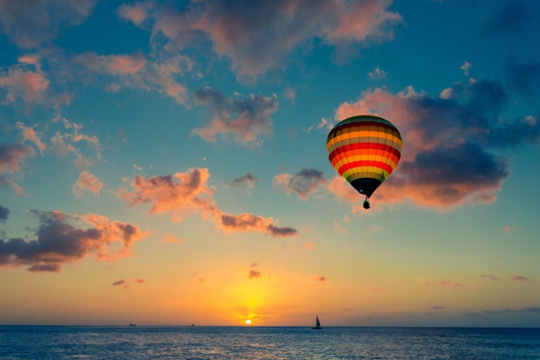 Air balloon over sea at sunset