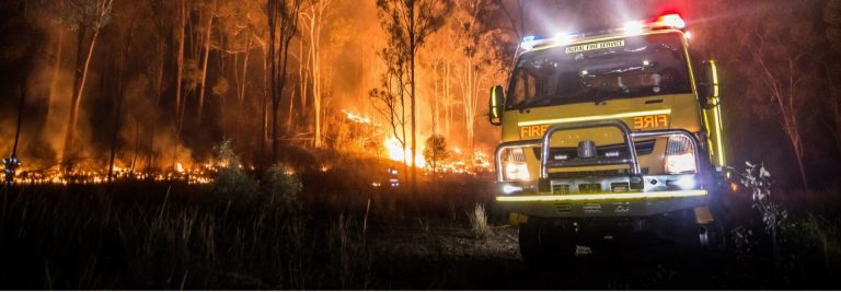 Yellow fire truck in a burning forest