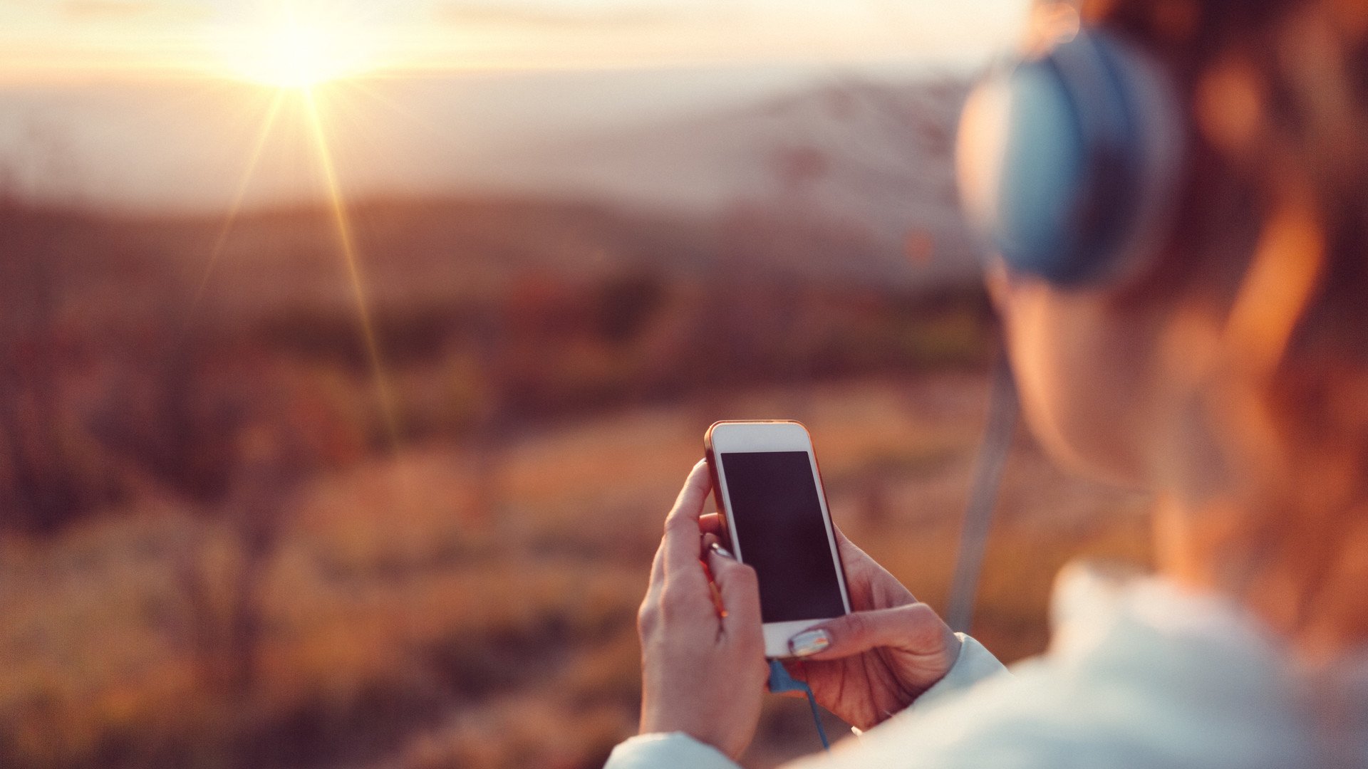 Woman on a mountain top listening music