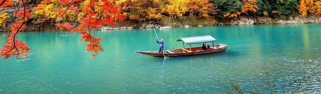 People sailing in a boat on the river among trees