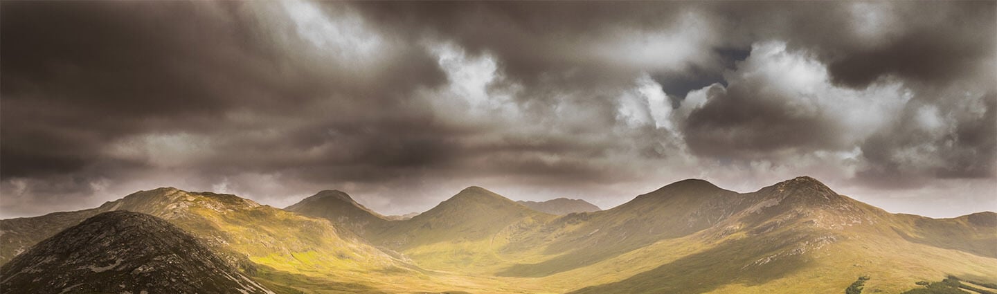 Storm clouds over the green mountains