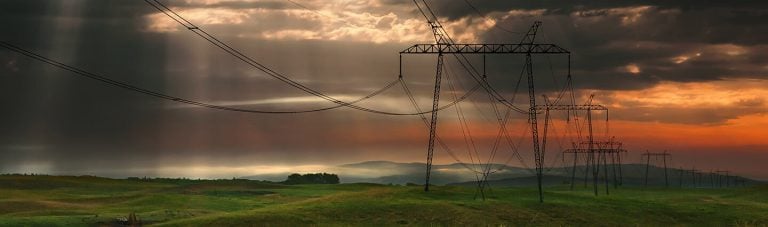 Row of electricity poles in a field