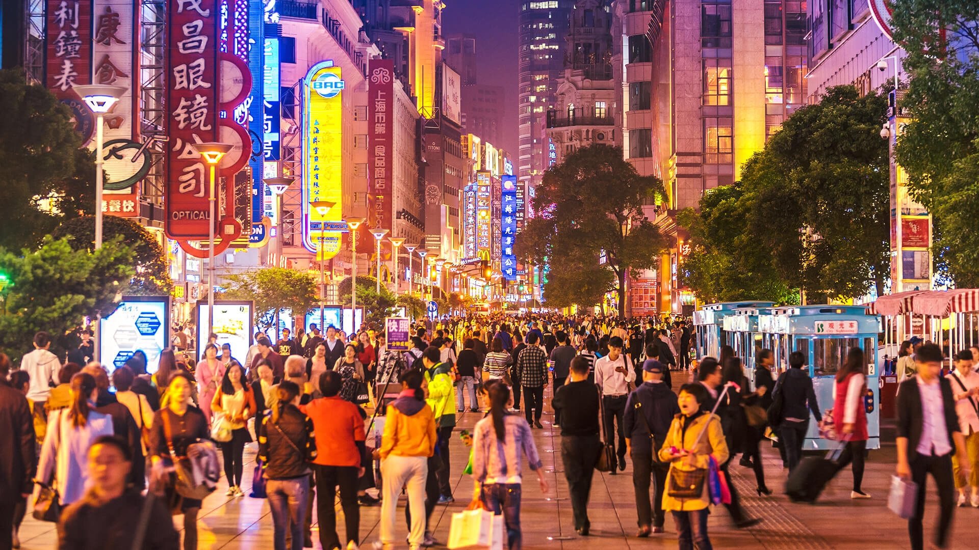 A street full of people in China at night