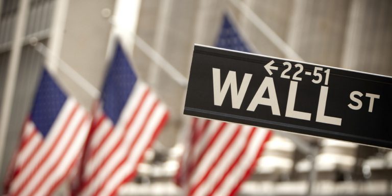 Wall Street sign at the US flags background