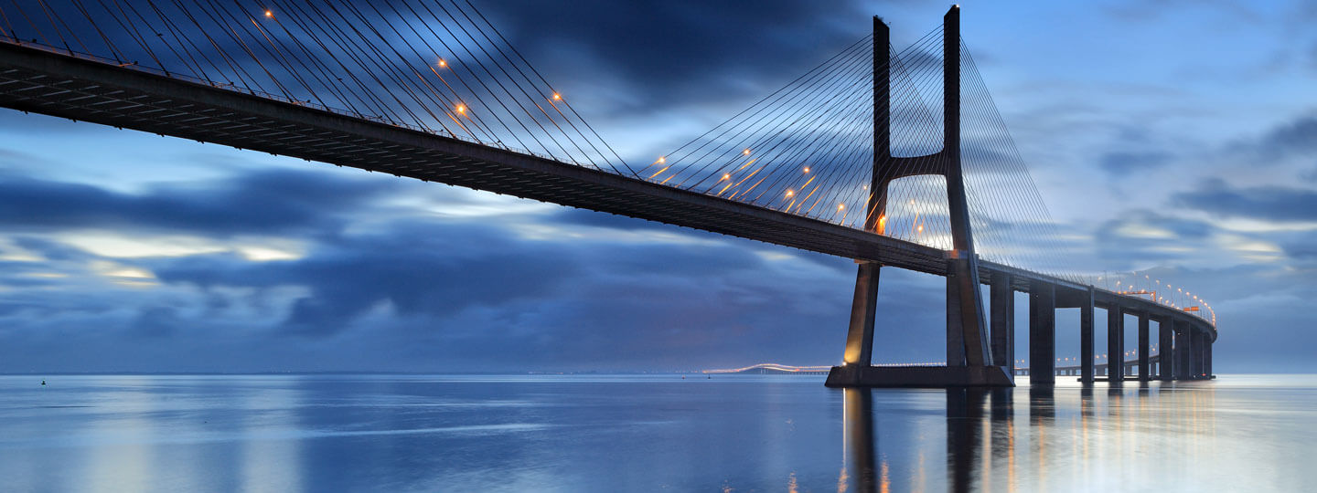 A long bridge with illuminated ropes over the water