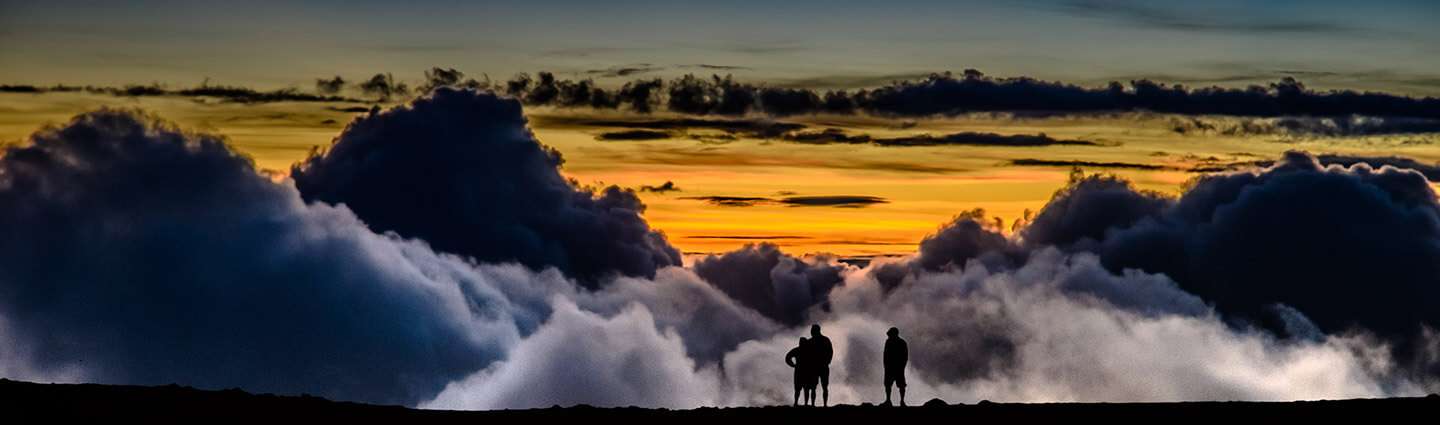 Silhouettes of people against the clouds