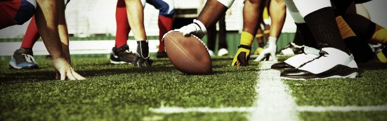 Rugby ball and team members legs