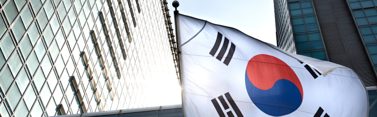 An image showing the South Korean flag flying outside a high-rise office building.