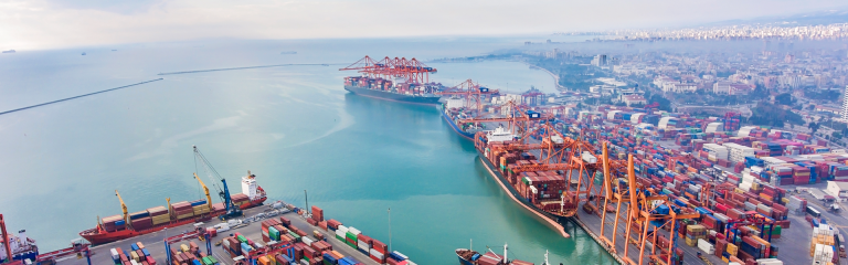 image of commercial port at a bay with lots of shipping containers