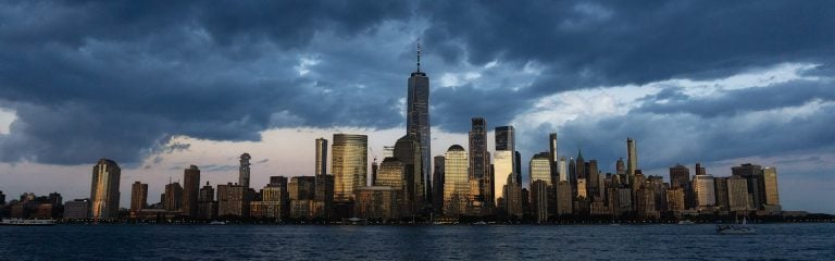 Manhattan waterfront under a stormy sky.