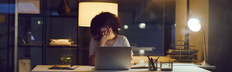 lady working at desk at night, looking stressed