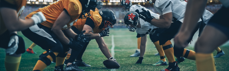 Two opposing American football teams square off on the pitch