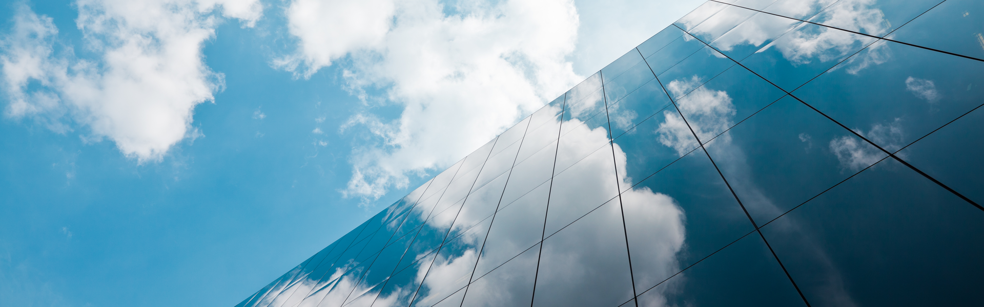 clouds reflected in the glass windows of a skyscraper