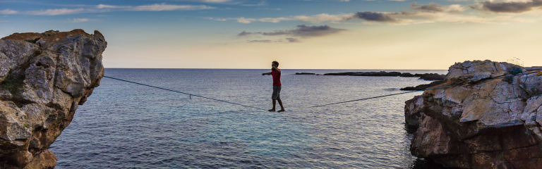 Man walking a slackline over the sea