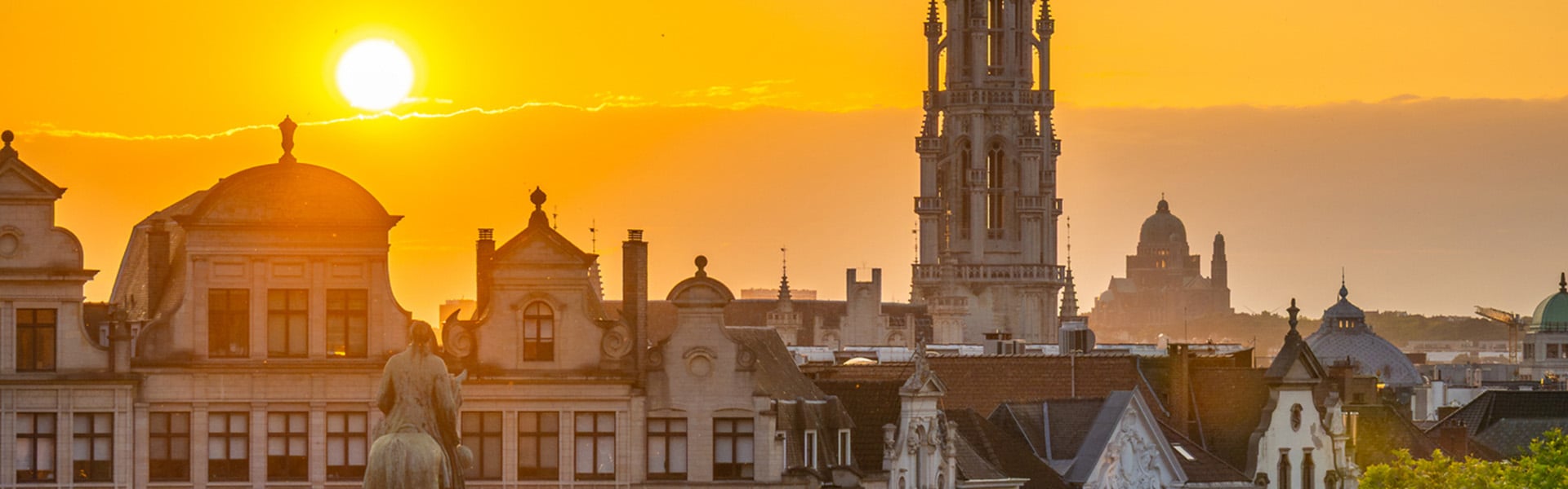 Sunset over gabled house rooftops in the Low Countries, with cropped view of Northern Renaissance bell tower.