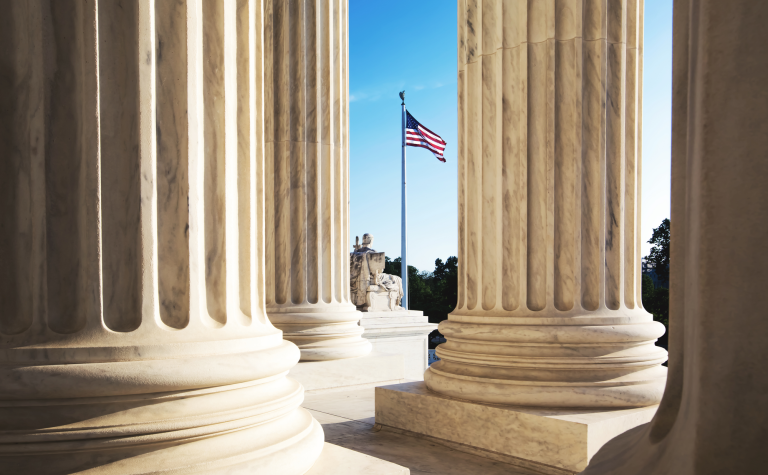 columns at the Lincoln memorial in Washington with a flag in the background